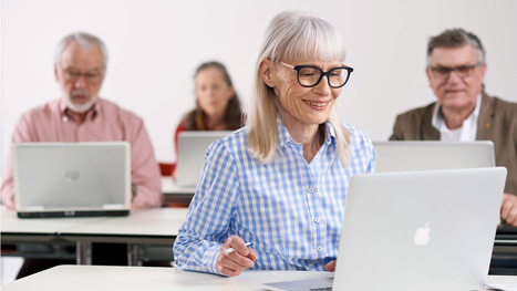 Eine Frau schaut lächelnd in ihren Laptop