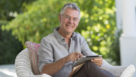 Ein Mann sitzt mit einem Buch auf dem Sofa